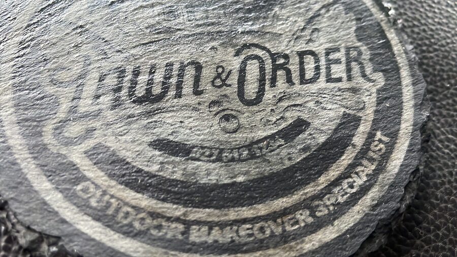 Lawn & Order slate coaster with the logo